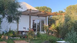a small white house with a wooden pergola at Sítio Do Valverde in Coruche