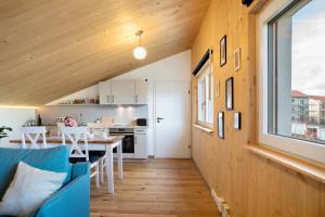 a kitchen and living room with wooden walls and a blue couch at Refugium aus Vollholz in Schlitz