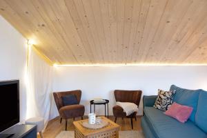 a living room with a blue couch and two chairs at Refugium aus Vollholz in Schlitz