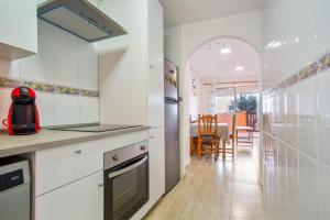 a kitchen with white cabinets and a dining room at Los Tinajones in La Oliva