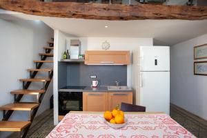 a kitchen with a table with a bowl of fruit on it at Hora Est in Orosei +12 photos
