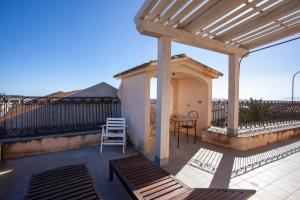 a patio with a pergola and a table and chairs at Hora Est in Orosei