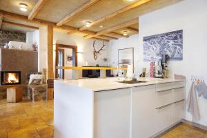 a kitchen with white cabinets and a fireplace at Chalet Fluh in Oberstaufen