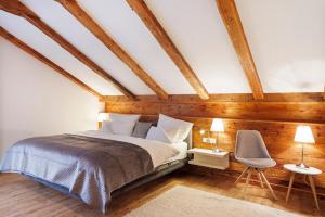 a attic bedroom with a bed and a chair at Chalet Fluh in Oberstaufen