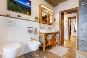 a bathroom with a white toilet and a sink at Chalet Fluh in Oberstaufen +35 photos
