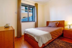 a bedroom with a bed and a window at Casa da Bemposta in Machico