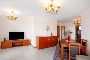 a living room with a dining table and a television at Casa da Bemposta in Machico