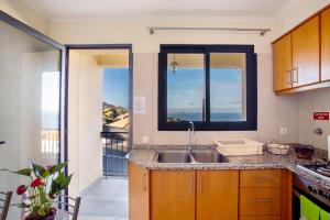 a kitchen with a sink and a large window at Casa da Bemposta in Machico