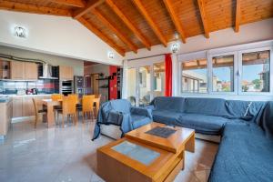 a living room with a blue couch and a table at Eli Guesthouse in Kavos