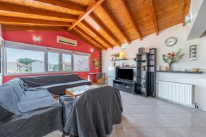 a living room with a couch and a tv at Eli Guesthouse in Kavos