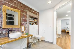 a bathroom with a white sink and a brick wall at Ferienwohnung Seyfried in Hardheim +19 photos