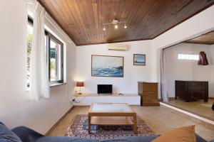 a living room with white walls and a wooden ceiling at A Cerca - A in Lagos