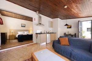 a living room with a blue couch and a bedroom at A Cerca - A in Lagos