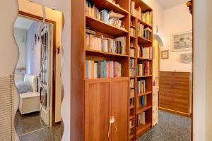 a library with wooden shelves filled with books at A due passi dal mare in Pietra Ligure