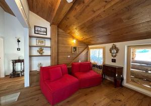 a living room with a red couch and a wooden ceiling at Maso 1445,Quiet, Breathtaking Views in Siror