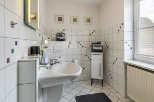 a white bathroom with a sink and a window at Ferienwohnung Griesbaum in Tengen