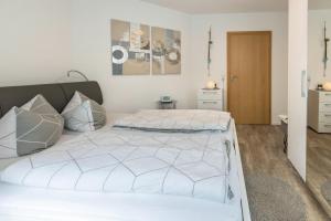 a bedroom with a bed with white sheets at Ferienwohnung Griesbaum in Tengen