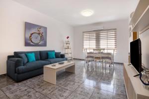 a living room with a blue couch and a table at Casa Relax in Gran Tarajal