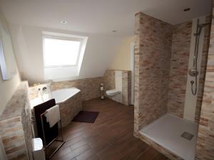 a bathroom with a shower and a tub and a toilet at Ferienhaus Paula in Forbach +26 photos