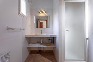 a white bathroom with a sink and a mirror at Maison d'hôtes Collobrières in Collobrières