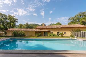 a villa with a swimming pool in front of a house at Maison d'hôtes Collobrières in Collobrières
