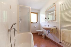 a bathroom with a tub shower and a sink at Leitnerhof in Racines