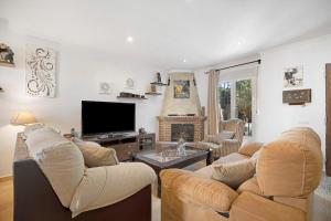 a living room with two couches and a flat screen tv at Villa Viruta in El Bosque