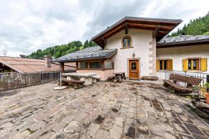 a house with a patio with benches in front of it at Casa Montagna in Cadore in San Pietro di Cadore