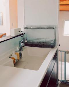 a bathroom with a dish drying rack on the wall at Chigasaki Southern Beach House 茅ヶ崎サザンビーチハウス in Chigasaki