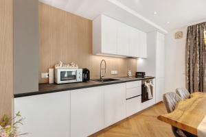 a kitchen with white cabinets and a microwave at Ferienwohnung Reichenau in Reichenau