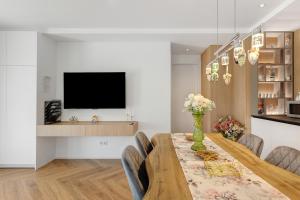 a dining room with a table and chairs and a television at Ferienwohnung Reichenau in Reichenau