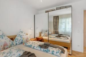 a bedroom with two beds and a large mirror at Ferienwohnung Reichenau in Reichenau