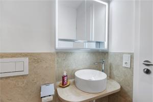 a bathroom with a white sink and a cabinet at Ferienwohnung Reichenau in Reichenau +12 photos
