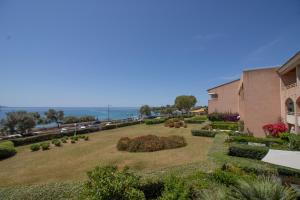 a large yard with bushes and flowers in front of a building at Résidence Aria Marina Plage in Ajaccio