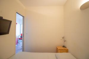 a bedroom with two beds and a television and a table at Résidence Aria Marina Plage in Ajaccio