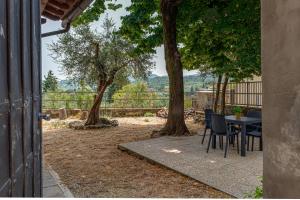 a patio with a table and chairs and trees at Villa Carmela in Lastra a Signa