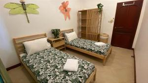 a room with two beds and a butterfly on the wall at Thailand Dream Village E09 in Klaeng