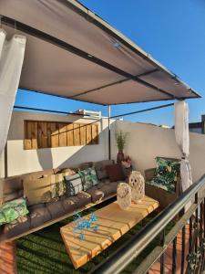 a couch under a patio umbrella on a deck at Villa Gení in La Victoria