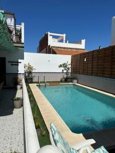 a swimming pool with chairs and a building at Villa Gení in La Victoria
