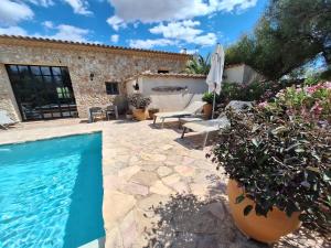 a patio with a swimming pool and a house at Casa Cascada in Costitx