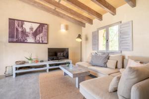 a living room with a couch and a tv at Casa Cascada in Costitx