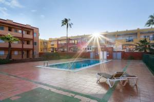 a swimming pool in a courtyard with a chair next to a building at Los Tinajones in La Oliva