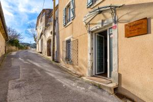 an empty street next to a building with a door at Forgerole in Faugères