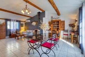 a dining room and living room with a glass table and chairs at Forgerole in Faugères