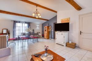 a living room with a tv and a table at Forgerole in Faugères
