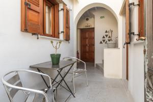 a table and chairs in a hallway with a door at En Tino 2 in Tinos