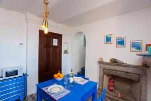 a dining room with a blue table and a fireplace at Hora Mare in Orosei