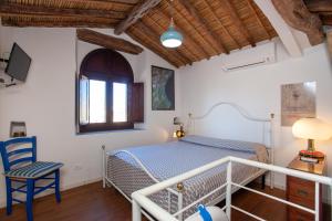 a bedroom with a bed and a desk and a chair at Hora Mare in Orosei