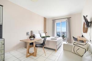 ein Schlafzimmer mit Bett und Schreibtisch und ein Zimmer mit Aussicht in der Unterkunft Sunset Premium Studio B in Lefkada Town
