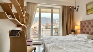 a bedroom with a bed and a large window at Central Premium Apartment in Braşov +74 photos